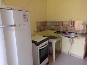 a small kitchen with a refrigerator and a sink at Lugar de paz! in Marataizes
