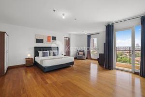 ein Schlafzimmer mit einem Bett und einem großen Fenster in der Unterkunft Tovia by Kozystay - Senayan in Jakarta + 39 Fotos