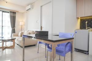 ジャカルタにあるElegant and Comfy 3BR Daan Mogot City Apartment By Travelioのキッチン(テーブル、青い椅子付)