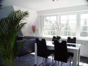 a dining room with a table and chairs and windows at Ferienwohnung La Domus Premium in Lotte