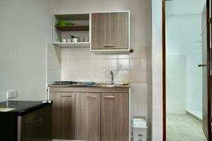 una piccola cucina con armadi in legno e lavandino di Apartaestudios la terraza 2 a Sincelejo