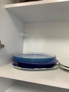a stack of blue plates sitting on a shelf at Aconchego Bertioga in Bertioga