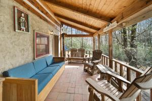 a porch with a blue couch and chairs on it at Creekside Cabin in Blowing Rock