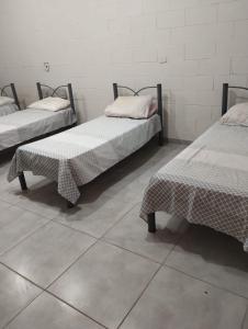 Lottus Moradia Corporativa في بيراسيكابا: ثلاثة أسرة تجلس في غرفة ذات أرضية من البلاط