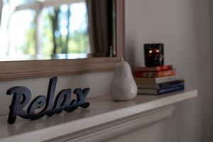 波高尔宾Villa Piccola Casa, Premier 2 Storey Villa, 2 Bedrooms, both with private ensuites, with third toilet on the ground floor的书架,有窗子,花瓶和书