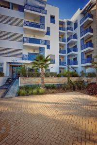 a building with a palm tree in front of it at Luxury apartment in martil in Martil