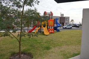 een park met een speeltuin met glijbanen en een boom bij Casa Lulu junto a Queretaro in Villa Apaseo