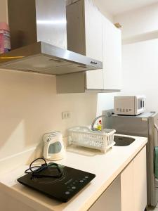 a kitchen with a counter with a sink and a microwave at Azure Staycation by Casa Lepap in Manila