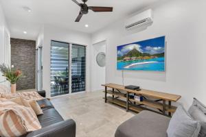 a living room with a couch and a table at Belle Escapes Canopy Heights in Palm Cove
