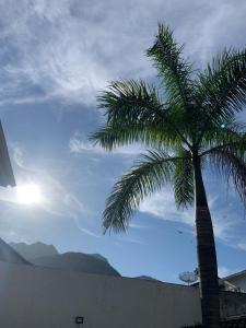 a palm tree with the sun in the sky at GH Casa da Montanha RJ - Jacarepaguá in Rio de Janeiro