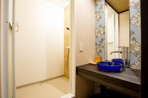 a bathroom with a blue sink and a mirror at Ukiyoan Takasago in Tokyo