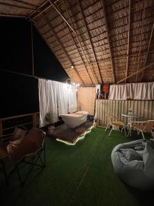 a room with a large room with a tub and chairs at Maka farmstay Thong Pha Phum สวนคุณตาฟาร์มสเตย์ in Ban Diso