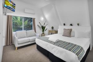 a bedroom with a bed and a chair and a window at Ingenia Holidays One Mile Beach in One Mile