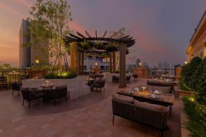 a restaurant on the roof of a building with tables and chairs at Anik Palace Hotel in Phnom Penh