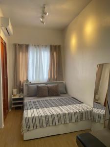 a bedroom with two beds in front of a window at L’s Cove Lapu- Lapu Cebu Condo in Lapu Lapu City