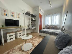 a living room with a couch and a bed at L’s Cove Lapu- Lapu Cebu Condo in Lapu Lapu City