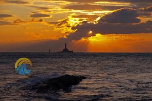 a person windsurfing in the ocean with a lighthouse in the background at Ferienwohnung für 2 Personen ca 30 qm in Premantura, Istrien Istrische Riviera in Premantura