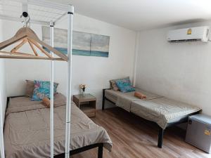 ein Schlafzimmer mit zwei Betten und einem Etagenbett in der Unterkunft Chuencheewa Resort in Pattaya South