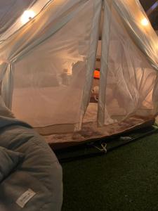 a tent with the door open in a room at มาค่ะ ฟาร์มสเตย์ ห้วยเขย่ง สวนคุณตา สวนทุเรียนทองผาภูมิ in Ban Diso