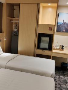 a hotel room with a bed and a flat screen tv at Hotel Damai Kuala Lumpur in Kuala Lumpur