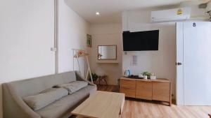 ein Wohnzimmer mit Sofa und Tisch in der Unterkunft Chuencheewa Resort in Pattaya South