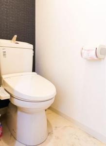 ein Badezimmer mit einer weißen Toilette in einem Zimmer in der Unterkunft F House Os Residence S2 in Osaka