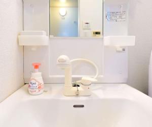 ein Badezimmer mit Waschbecken und Spiegel in der Unterkunft F House Os Residence S2 in Osaka