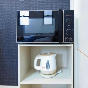 eine Mikrowelle und ein Toaster stehen auf einem Regal in der Unterkunft F House Os Residence S2 in Osaka