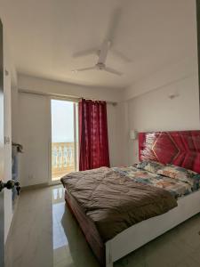 a bedroom with a large bed and a window at Cozy 2BHK, 10 mins from Airport and 20 mins from Station in Varanasi +14 photos