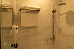 a bathroom with a shower with a phone in it at serene stay اقامة هادئة in Dammam