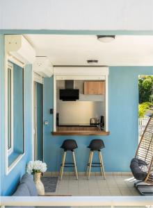 a kitchen with blue walls and two stools at L évasion Doré in Le Gosier