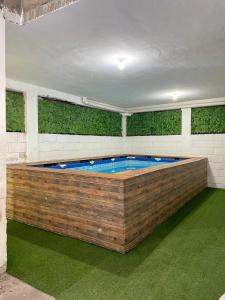 a large swimming pool in a room with green grass at Casa Marina Miramar in Ciudad Madero