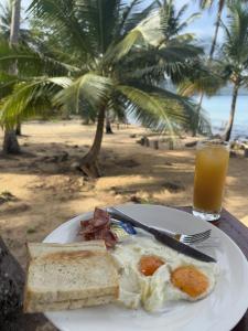 a plate of eggs and toast and a glass of orange juice at Lily's Beach Bungalows in Koh Rong Island
