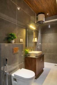 a bathroom with a white toilet and a sink at Host jatin Mountain Bibes Kasauli 7o1827o7o3 in Kasauli