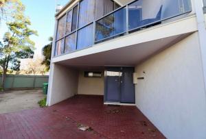 a building with a blue door and a brick driveway at 5 36 Maurice Avenue in Mallacoota