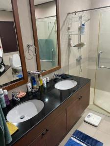 une salle de bain avec deux lavabos et une douche dans l'établissement Royal Apart Residence, à Phuket