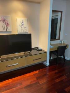 - un salon avec une commode et une télévision à écran plat dans l'établissement Royal Apart Residence, à Phuket