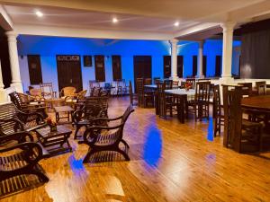 a restaurant with wooden chairs and tables and a blue wall at Hotel Indigo in Unawatuna
