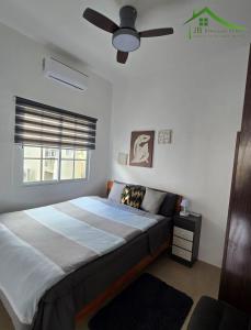 DauisにあるVilla Sarah Royal Palm Tres Panglao, Boholのベッドと天井扇風機のある寝室