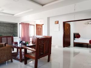 a living room with a table and chairs and a bed at VS HERITAGE INN in Vallam