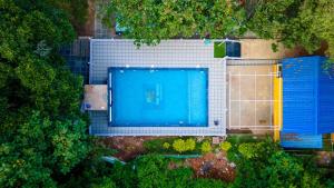 an overhead view of a swimming pool next to buildings at New river side cottages in Dandeli
