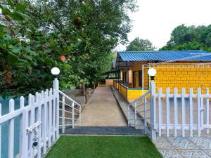 a white fence in front of a small house at New river side cottages in Dandeli