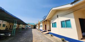 佛统Chok Phikul Thong Resort的旁边一排有停车位的建筑