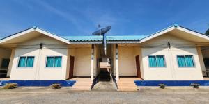 佛统Chok Phikul Thong Resort的一栋带蓝色窗户和卫星的建筑