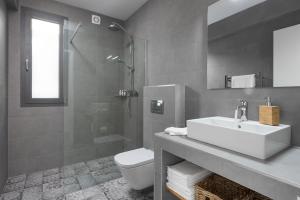 a bathroom with a sink and a toilet and a shower at Kathisma Bay Villas - Luxury Villas- Villa Oceanos in Kalamitsi +50 photos