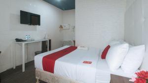 Postel nebo postele na pokoji v ubytování RedDoorz Premium at THE GRAND PENINSULA SUITES