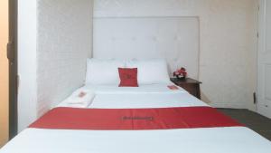 Postel nebo postele na pokoji v ubytování RedDoorz Premium at THE GRAND PENINSULA SUITES