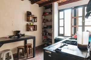 アンティグア・グアテマラにあるAmura Hostel - Antigua Guatemalaのキッチン(コンロ、カウンター、スツール付)