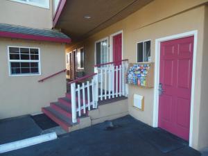 a building with a red door and a box of soda at Sealamp Inn in Seaside