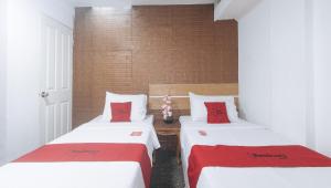 Postel nebo postele na pokoji v ubytování RedDoorz Premium at THE GRAND PENINSULA SUITES